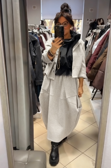 Płaszcz z kapeluszem i długą, luźną spódnicą z dużymi kieszeniami.