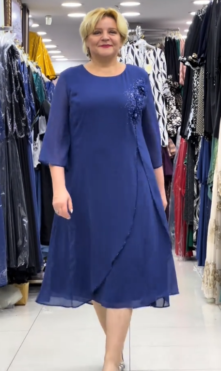 Prosta sukienka z okrągłym dekoltem, rękawami do kolan i wyjątkowymi zdobieniami z cekinów na ramionach.