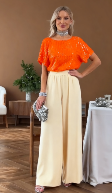 Garnitur z krótkim rękawem i okrągłym dekoltem, ozdobiony cekinami.