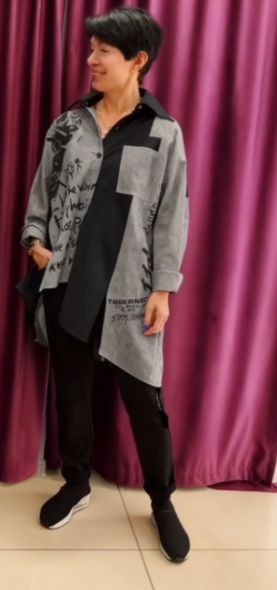 Luźna kurtka-koszula ozdobiona wzorami w stylu graffiti i elementami tekstowymi.