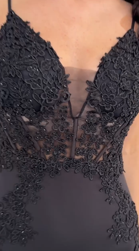 Sukienka na ramiączkach typu spaghetti z głębokim dekoltem w serek i wysokim rozcięciem, wykonana z półprzezroczystego materiału i ozdobiona aplikacjami.