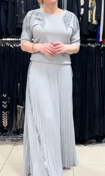 Elegancki garnitur z cekinowymi zdobieniami, krótkimi rękawami i okrągłym dekoltem.
