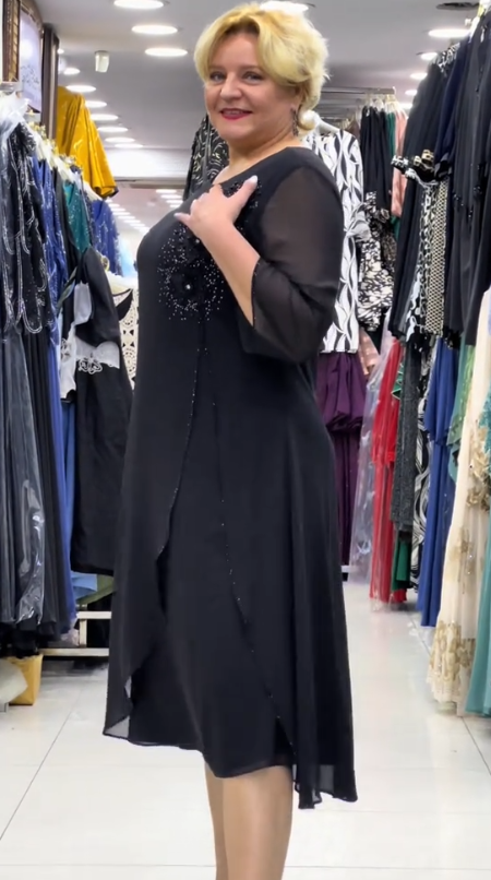 Prosta sukienka z okrągłym dekoltem, rękawami do kolan i wyjątkowymi zdobieniami z cekinów na ramionach.