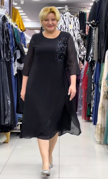 Prosta sukienka z okrągłym dekoltem, rękawami do kolan i wyjątkowymi zdobieniami z cekinów na ramionach.