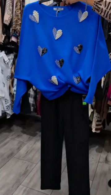 Marynarka ozdobiona wzorem w serca, zestawiona z czarnymi spodniami.