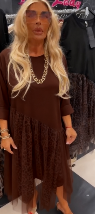 Sukienka z okrągłym dekoltem i długimi rękawami, ozdobiona półprzezroczystym, asymetrycznym nadrukiem.