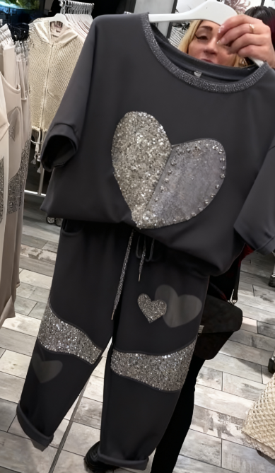 Prosty top z dekoltem w kształcie serca ozdobionym cekinami w połączeniu ze spodniami ozdobionymi serduszkami i cekinami.
