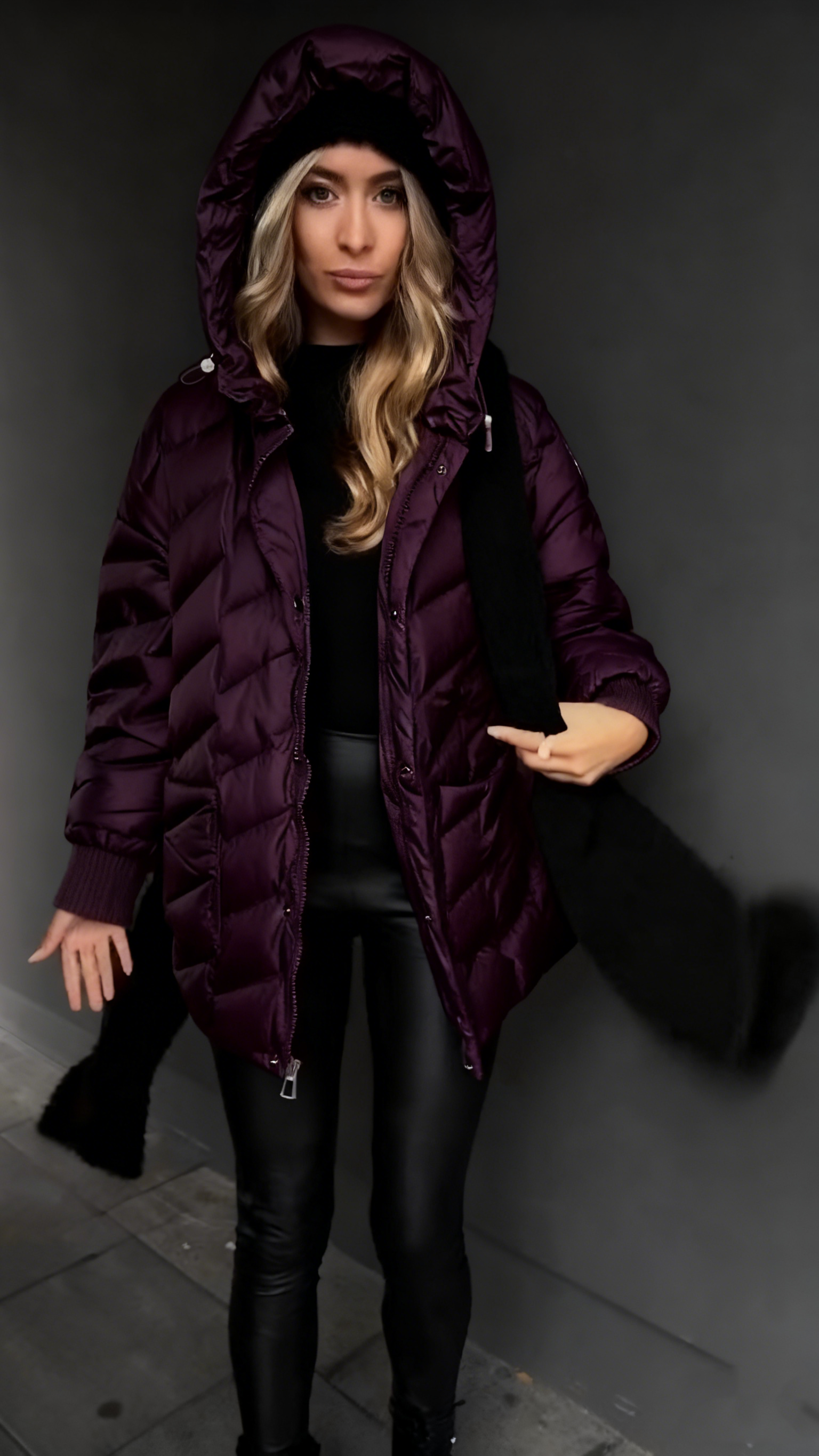 Kurtka puchowa z kapturem i fakturowaną fakturą, sięgająca do połowy łydki.