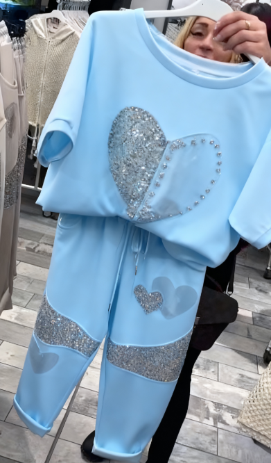 Prosty top z dekoltem w kształcie serca ozdobionym cekinami w połączeniu ze spodniami ozdobionymi serduszkami i cekinami.