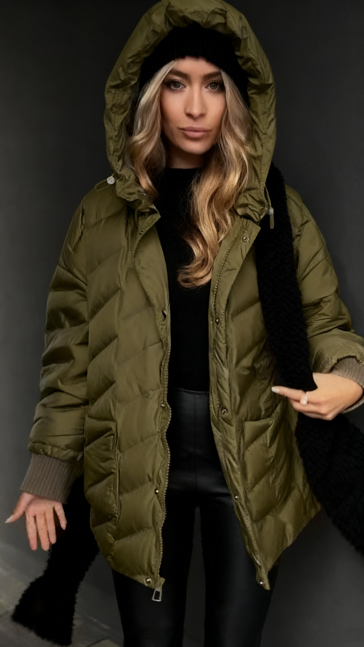 Kurtka puchowa z kapturem i fakturowaną fakturą, sięgająca do połowy łydki.