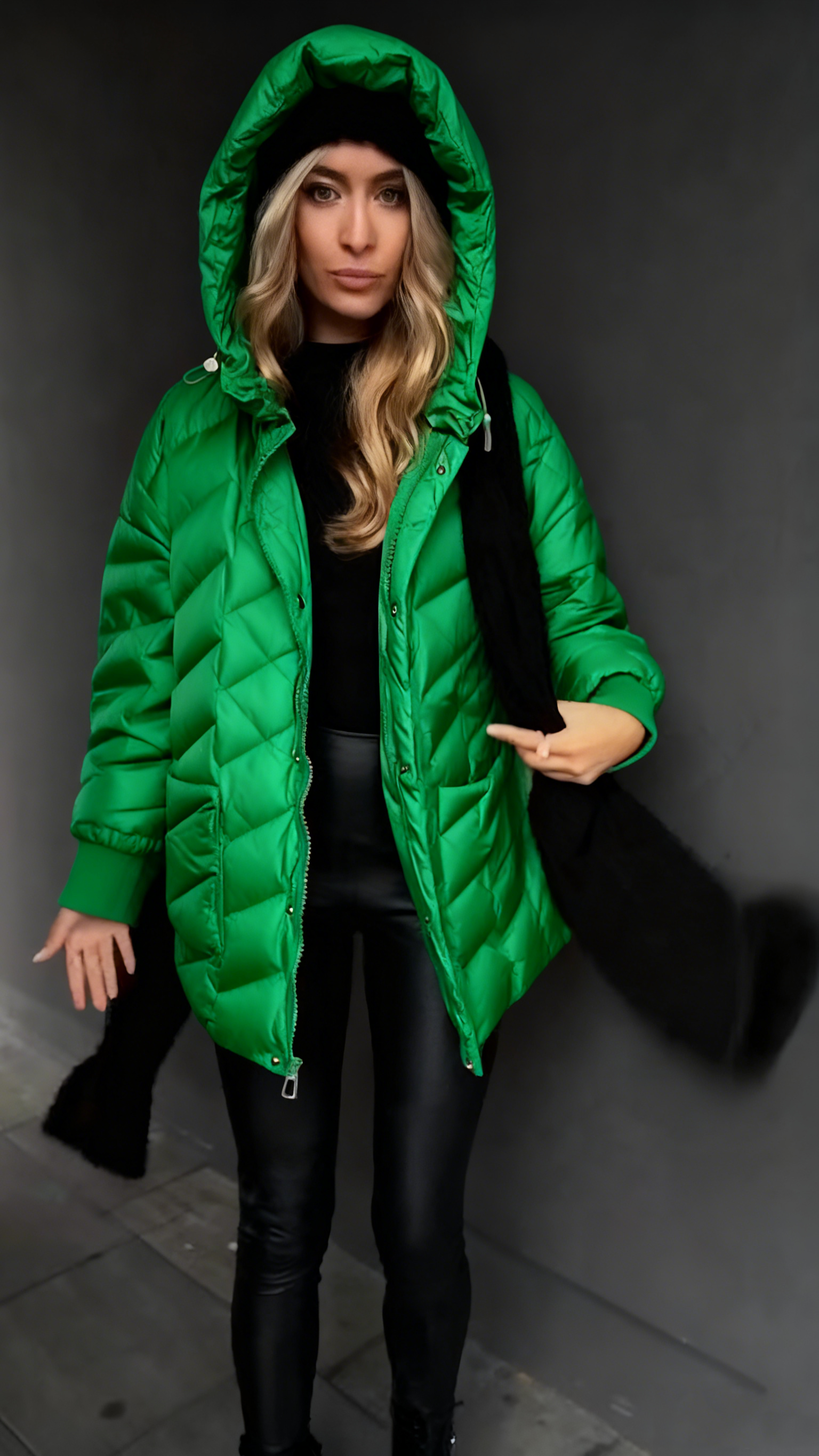 Kurtka puchowa z kapturem i fakturowaną fakturą, sięgająca do połowy łydki.