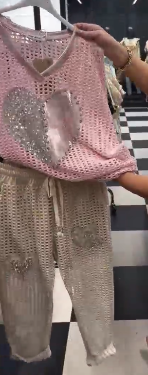 Strój składający się z koszuli z dekoltem w serek i spodni, ozdobiony wyjątkowymi wycięciami i cekinowymi sercami.