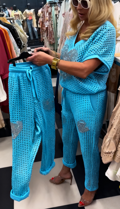 Strój składający się z koszuli z dekoltem w serek i spodni, ozdobiony wyjątkowymi wycięciami i cekinowymi sercami.