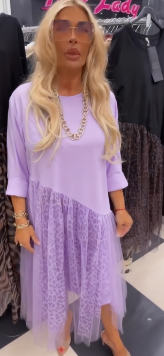 Sukienka z okrągłym dekoltem i długimi rękawami, ozdobiona półprzezroczystym, asymetrycznym nadrukiem.