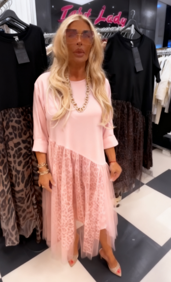 Sukienka z okrągłym dekoltem i długimi rękawami, ozdobiona półprzezroczystym, asymetrycznym nadrukiem.