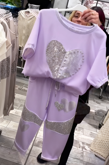 Prosty top z dekoltem w kształcie serca ozdobionym cekinami w połączeniu ze spodniami ozdobionymi serduszkami i cekinami.