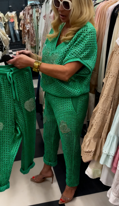 Strój składający się z koszuli z dekoltem w serek i spodni, ozdobiony wyjątkowymi wycięciami i cekinowymi sercami.