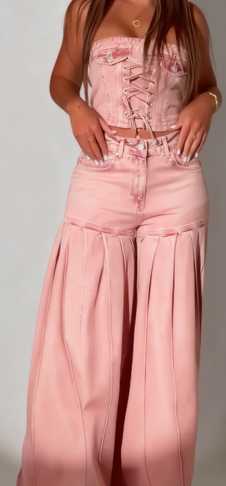 Stylowy strój składający się z jeansowego topu bez ramiączek i pasującej do niego pary plisowanych jeansów z szerokimi nogawkami.