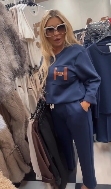 Strój składający się z bluzki ozdobionej ozdobnymi detalami w kształcie litery „H” oraz wygodnych spodni z kieszeniami.