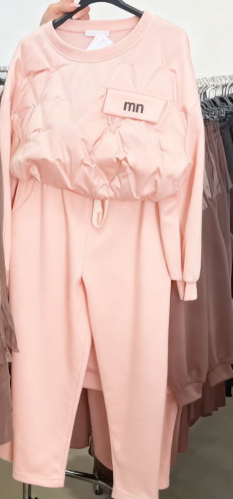 Zestaw składa się z koszuli z długim rękawem i okrągłym dekoltem oraz wygodnych spodni ze ściągaczem.