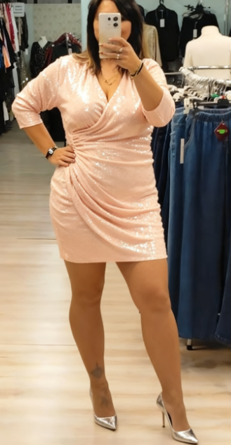 Sukienka z cekinowymi detalami, głębokim dekoltem w serek i rękawami o długości do połowy łydki.