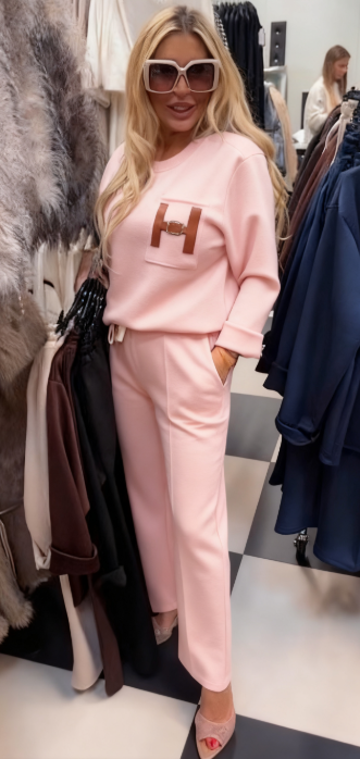 Strój składający się z bluzki ozdobionej ozdobnymi detalami w kształcie litery „H” oraz wygodnych spodni z kieszeniami.