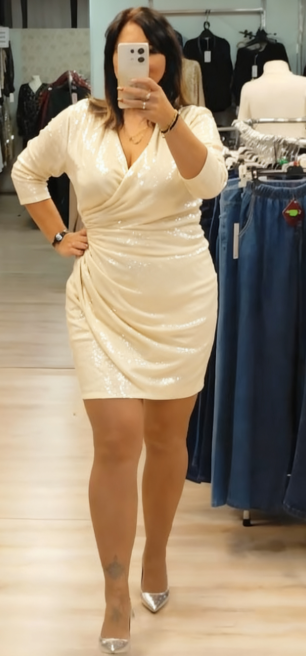 Sukienka z cekinowymi detalami, głębokim dekoltem w serek i rękawami o długości do połowy łydki.