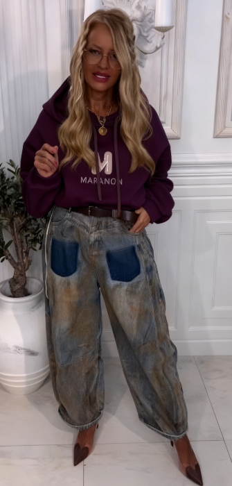 Bluza z kapturem z wyjątkowym wzorem liter w połączeniu z luźnymi jeansami w kontrastujących kolorach.
