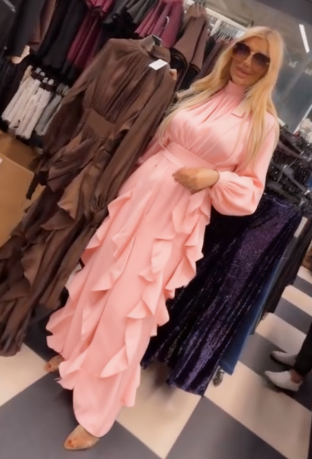 Sukienka ta charakteryzuje się licznymi falbanami w talii i plisowanymi długimi rękawami.