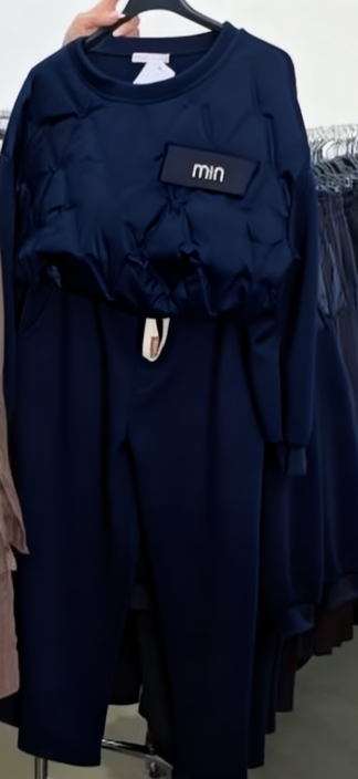 Zestaw składa się z koszuli z długim rękawem i okrągłym dekoltem oraz wygodnych spodni ze ściągaczem.