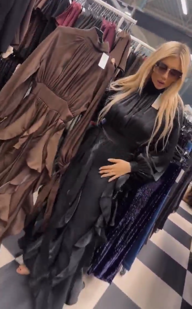 Sukienka ta charakteryzuje się licznymi falbanami w talii i plisowanymi długimi rękawami.