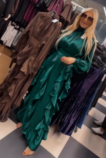 Sukienka ta charakteryzuje się licznymi falbanami w talii i plisowanymi długimi rękawami.