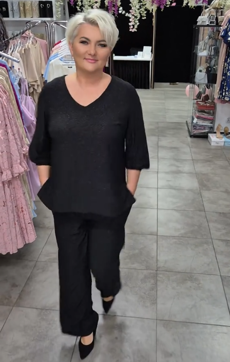 Prosty, a zarazem elegancki garnitur składający się z koszuli z okrągłym dekoltem i spodni.