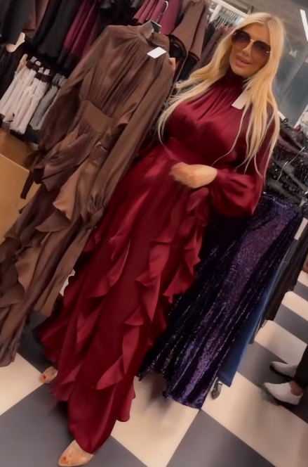 Sukienka ta charakteryzuje się licznymi falbanami w talii i plisowanymi długimi rękawami.