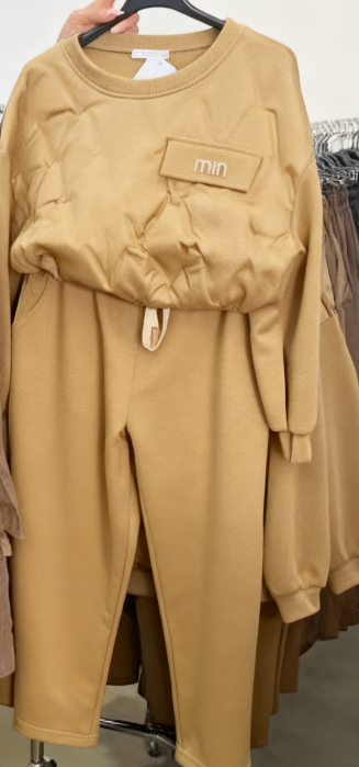 Zestaw składa się z koszuli z długim rękawem i okrągłym dekoltem oraz wygodnych spodni ze ściągaczem.