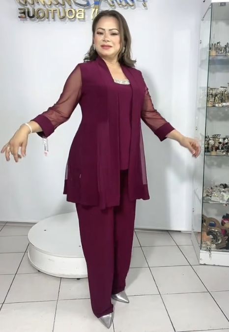 Strój składa się z eleganckiej kurtki z przezroczystymi rękawami, koszuli bez rękawów i luźnych spodni.