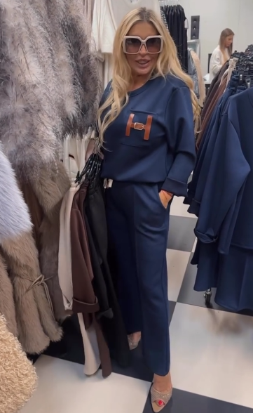 Strój składający się z bluzki ozdobionej ozdobnymi detalami w kształcie litery „H” oraz wygodnych spodni z kieszeniami.