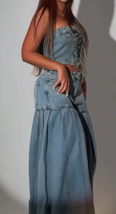 Stylowy strój składający się z jeansowego topu bez ramiączek i pasującej do niego pary plisowanych jeansów z szerokimi nogawkami.