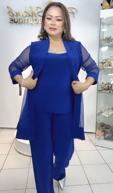 Strój składa się z eleganckiej kurtki z przezroczystymi rękawami, koszuli bez rękawów i luźnych spodni.