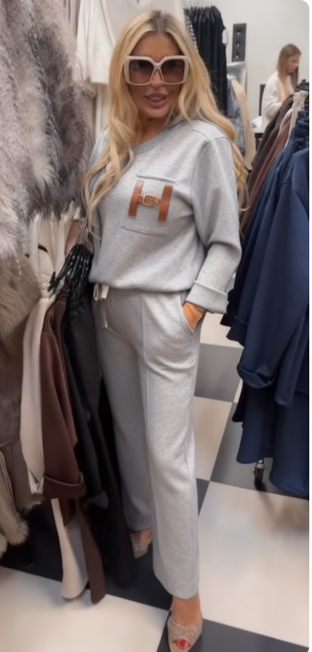 Strój składający się z bluzki ozdobionej ozdobnymi detalami w kształcie litery „H” oraz wygodnych spodni z kieszeniami.