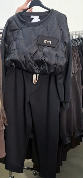 Zestaw składa się z koszuli z długim rękawem i okrągłym dekoltem oraz wygodnych spodni ze ściągaczem.