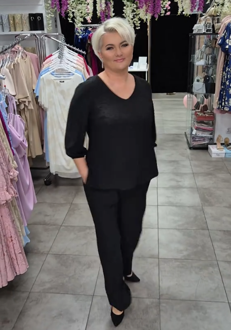 Prosty, a zarazem elegancki garnitur składający się z koszuli z okrągłym dekoltem i spodni.