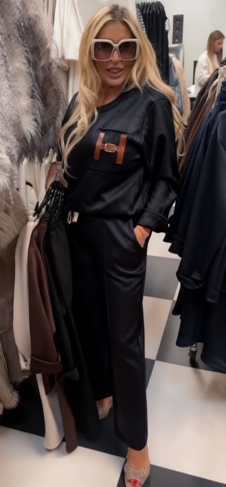 Strój składający się z bluzki ozdobionej ozdobnymi detalami w kształcie litery „H” oraz wygodnych spodni z kieszeniami.