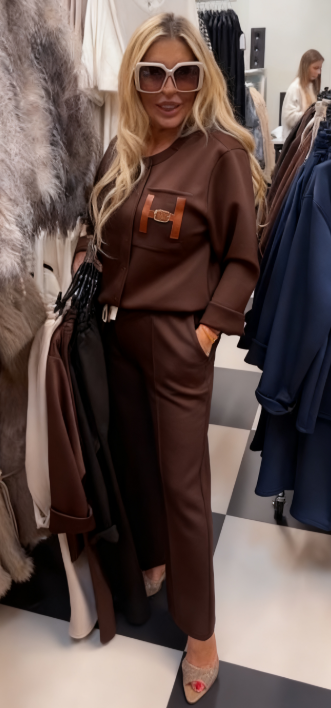 Strój składający się z bluzki ozdobionej ozdobnymi detalami w kształcie litery „H” oraz wygodnych spodni z kieszeniami.