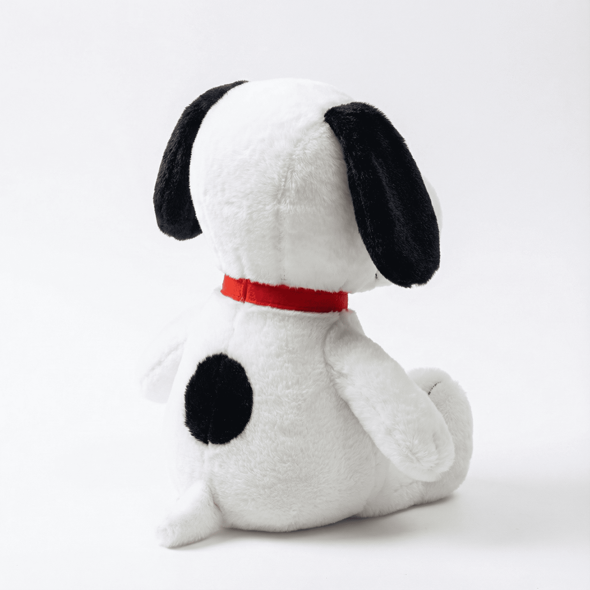 Side and back view of the Snoopy plush showing its red collar and black back spot