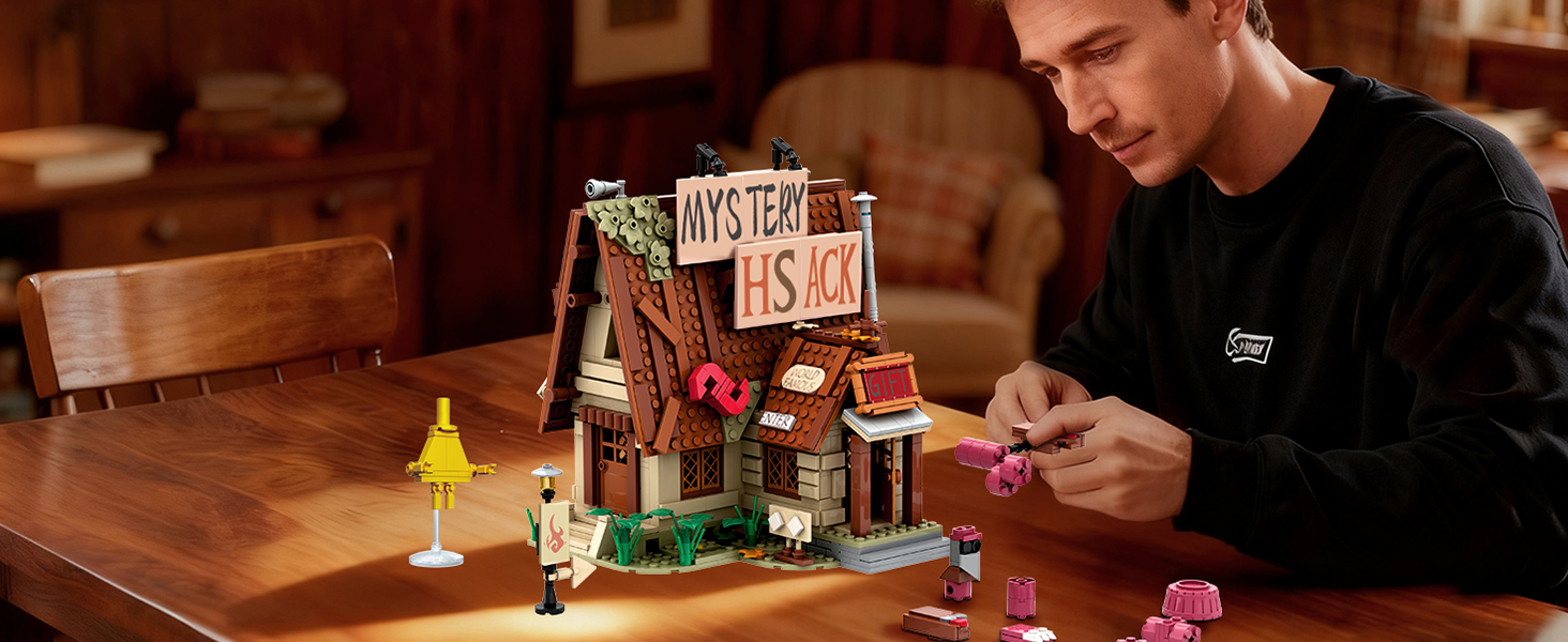 Adult builder arranging accessories beside the completed Mystery House building set