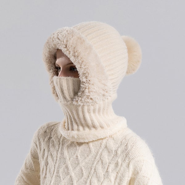 Beige pom pom knit winter hood worn with face covering pulled up