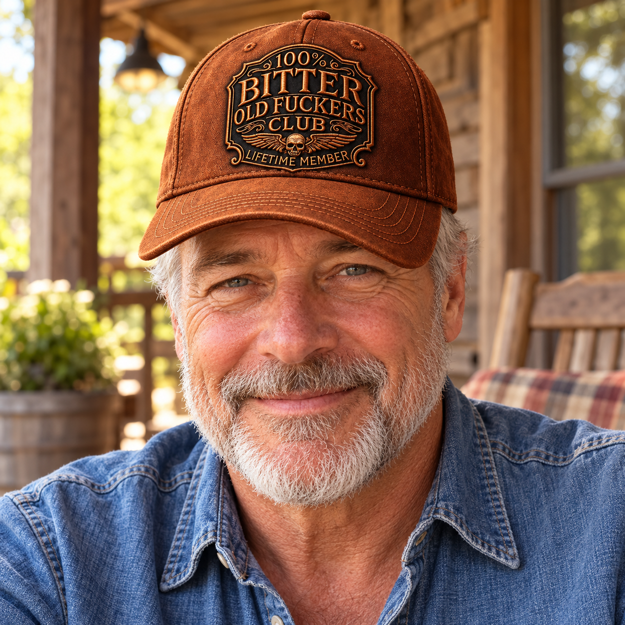A mature man wearing the rust brown Lifetime Member cap with a casual denim shirt outdoors