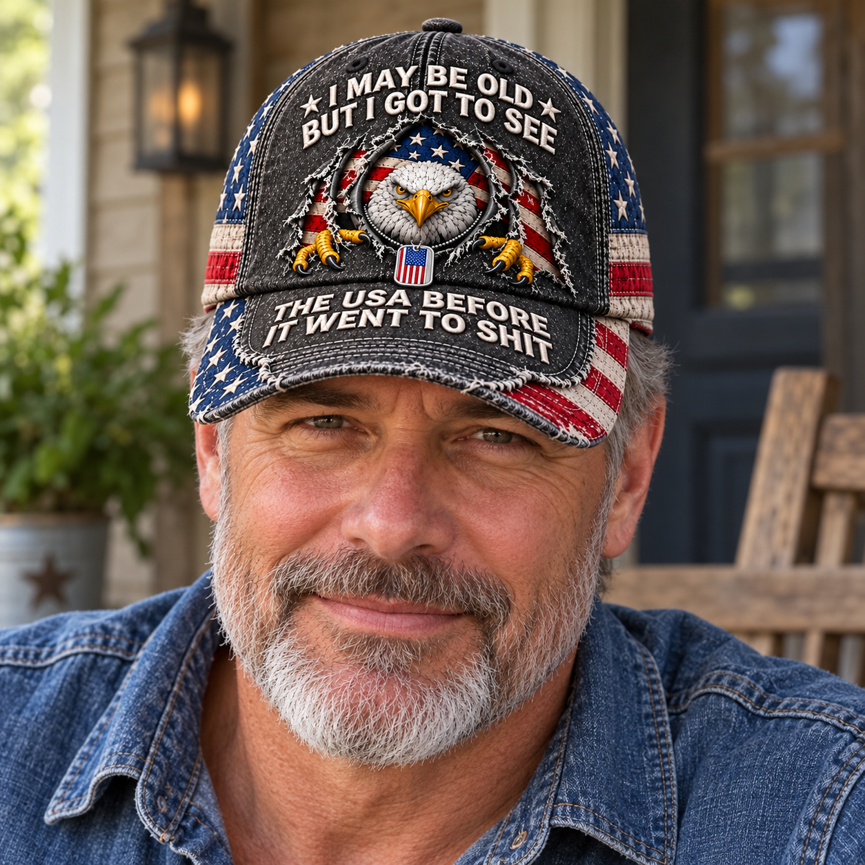 A mature man wearing the distressed eagle and flag baseball cap with casual denim outdoors