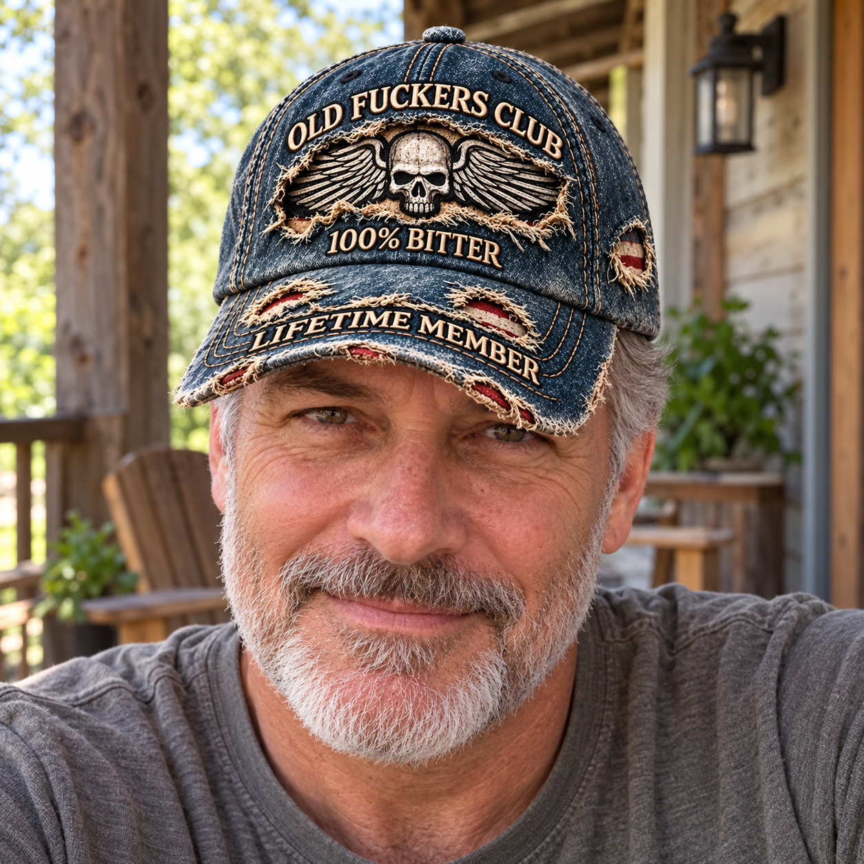 A mature man wearing the dark washed-blue winged skull cap on a casual outdoor porch